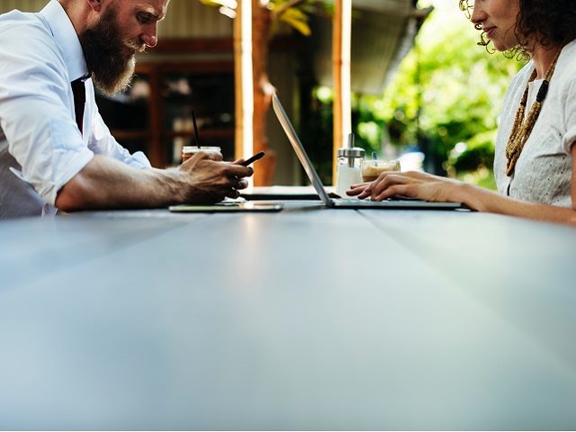 Man and woman shopping on mobile devices. 
