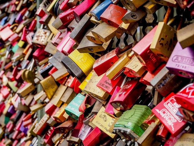 every inch of a fence covered in multi-colored locks