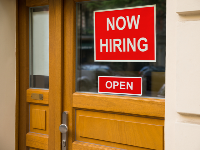 Now Hiring sign on storefront