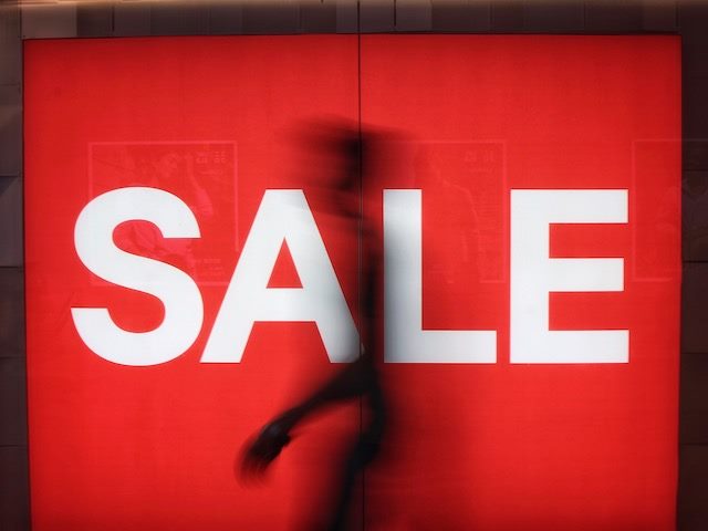 silhouette in front of a sale sign