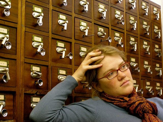 a librarian, in front of a card catalogue