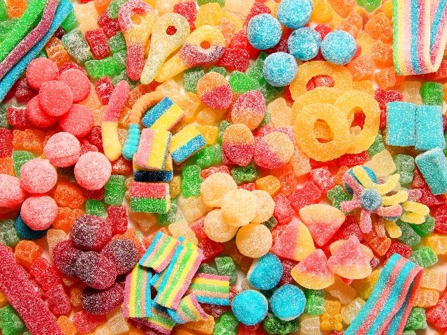 Assorted variety of sour candies including extreme sour soft fruit chews, keys, tart candy belts and straws.