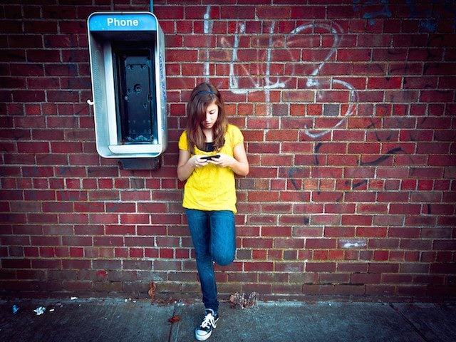 on cellphone, next to defunct payphone