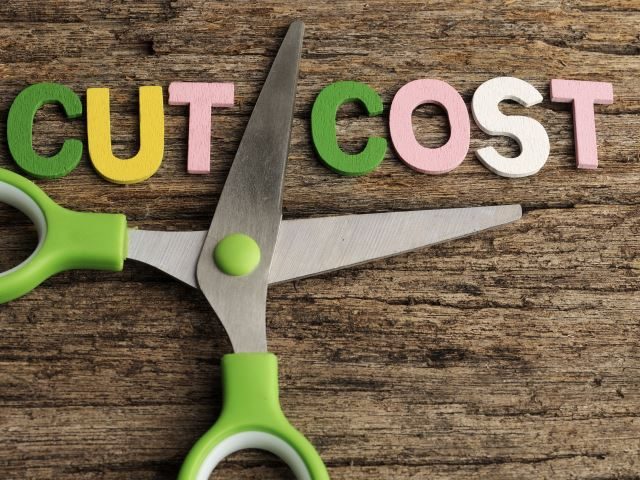  Scissors with words CUT COST word written on wooden background - martech bloat concept